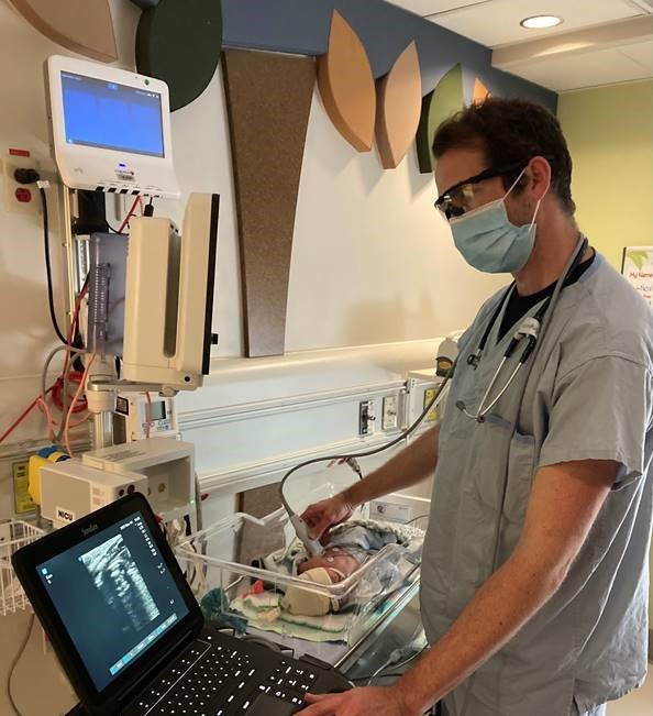 A respiratory therapist uses the point-of-care ultrasound system donated by the Sandra Schmirler Foundation to help a baby in the Grey Nuns NICU
